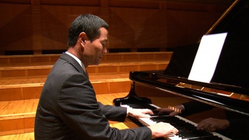 テレビCMのためにピアノを演奏する桑田真澄さん